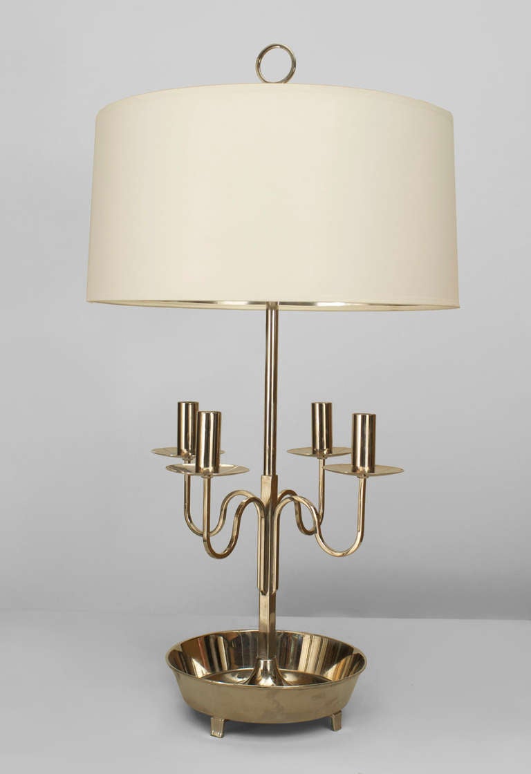 1950's American table lamp by Parzinger with a round silver trimmed shade supported by a silver plate base with four curved candlestick arms and a round bowl base raised on four small feet.