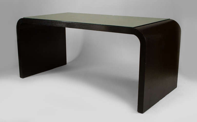 Attributed to Osvaldo Borsani, this 1940's Italian table desk is composed of ebonized oak and features an open design with solid pedestal sides centering a silver leaf top sheathed in a protective glass panel.