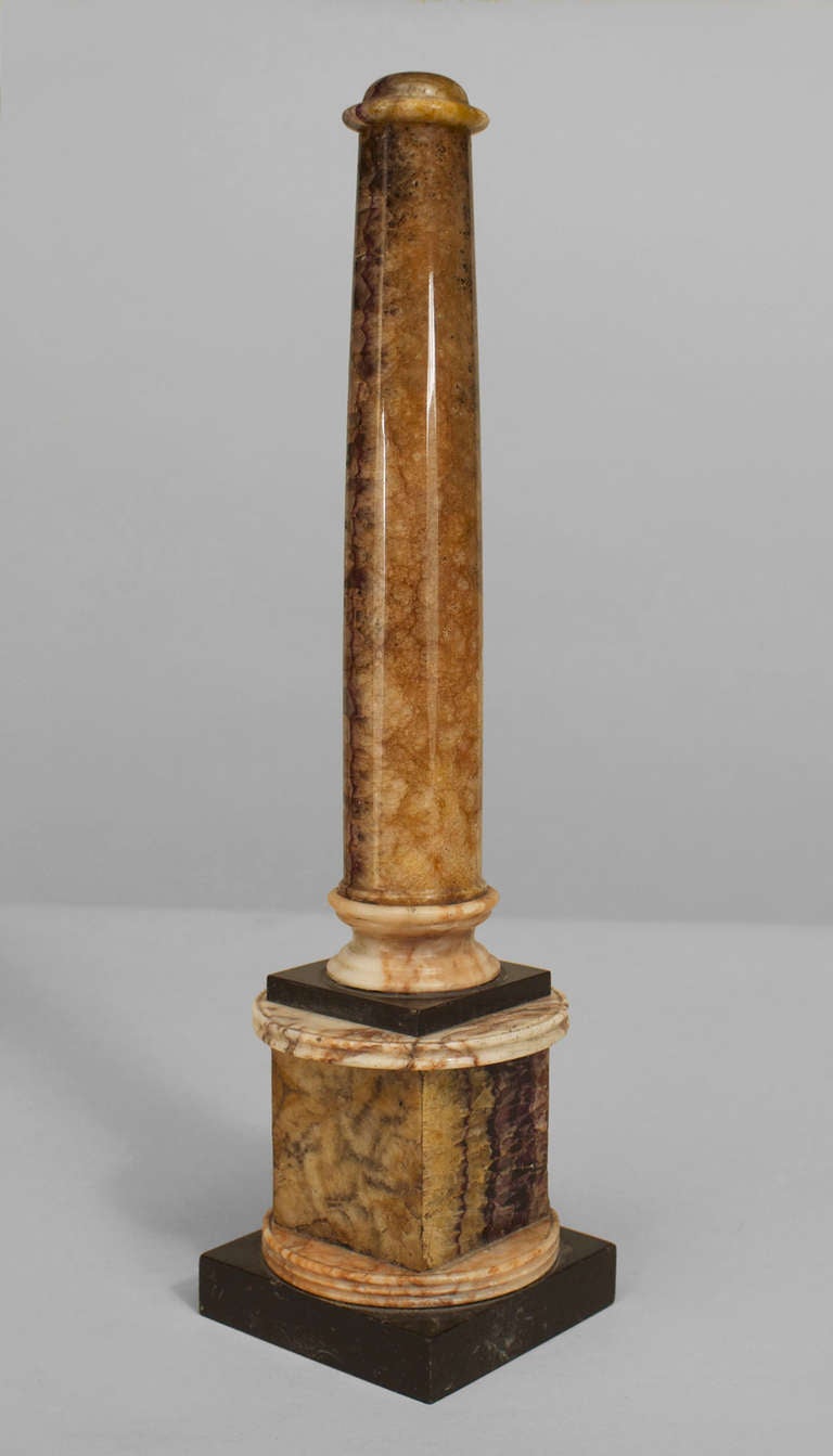 Rare pair of small Blue John columns dating to the English Regency period. These columns are cylindrical in form and rest upon a square pedestal base with white and black marble accents.