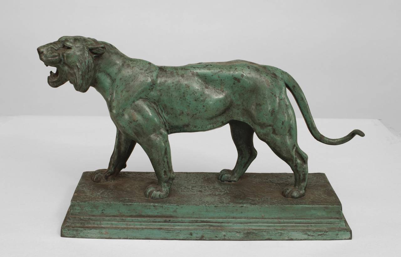 Signed Barye, a pair of 20th century French green patina metal figures of a roaring lion and lioness.