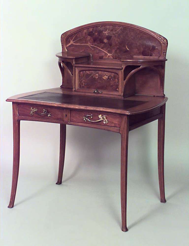 French Art Nouveau walnut ladies desk with an inlaid upper structure with shelves, a doored cabinet, and two drawers finished with bronze handles.
