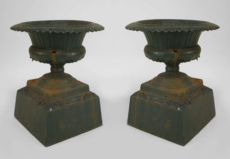 Pair of Outdoor green painted iron urns with a round ogee scalloped top resting on a square base (signed: THE KRAMER BROS FDR CO DAYTON O) (PRICED AS Pair)
