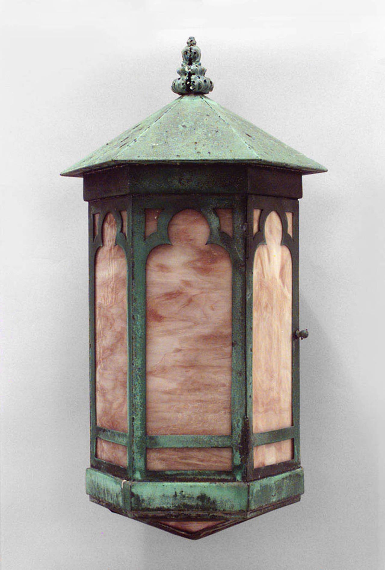 Pair of 19th century American green patinated copper outdoor 6-sided hanging lanterns with arch designs and colored glass panels and finial tops.