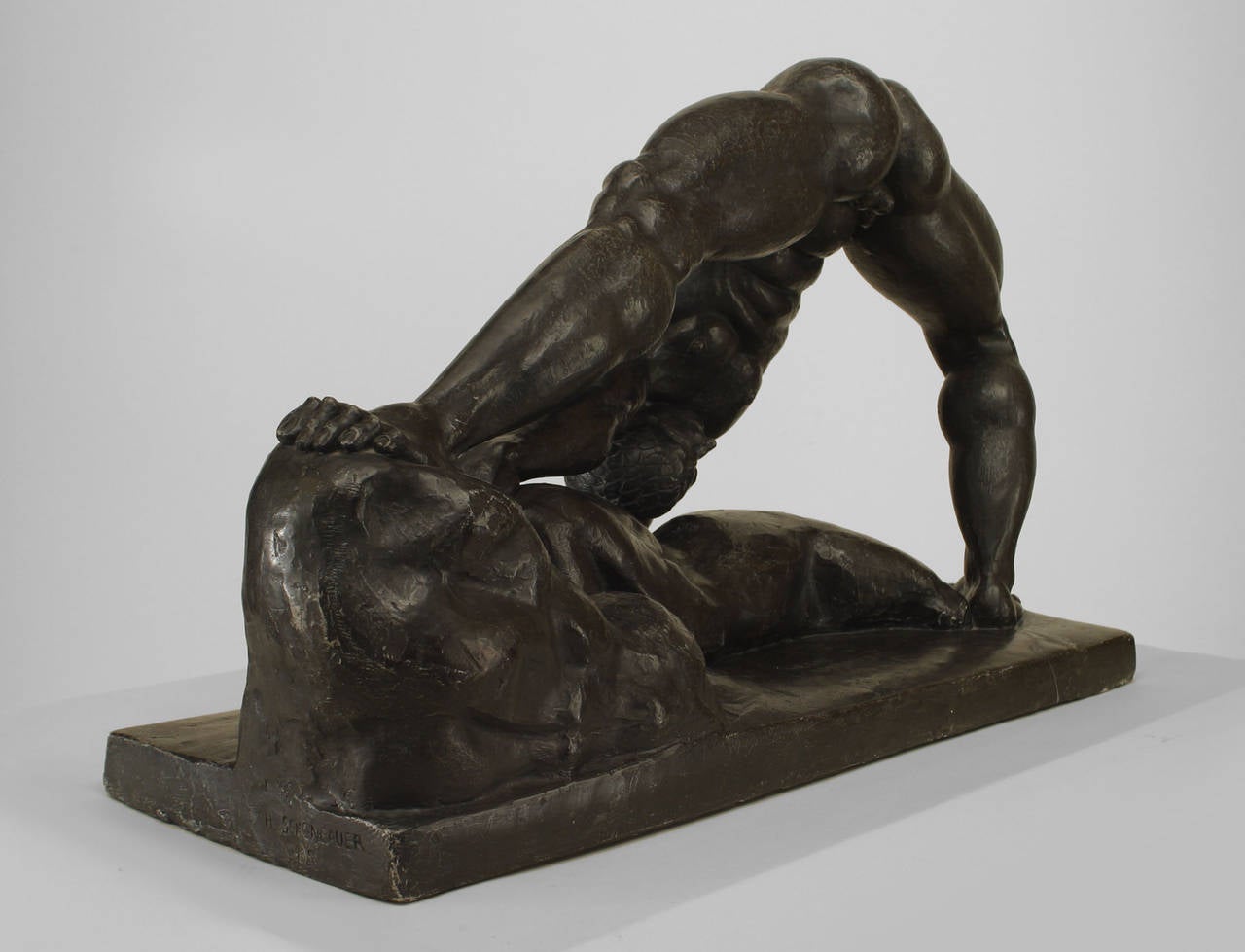 Copie moderne en résine moulée d'une sculpture Art déco hongroise signée par Henry Scheonbauer. La sculpture représente une figure masculine aux jambes écartées, debout sur un socle rocheux.