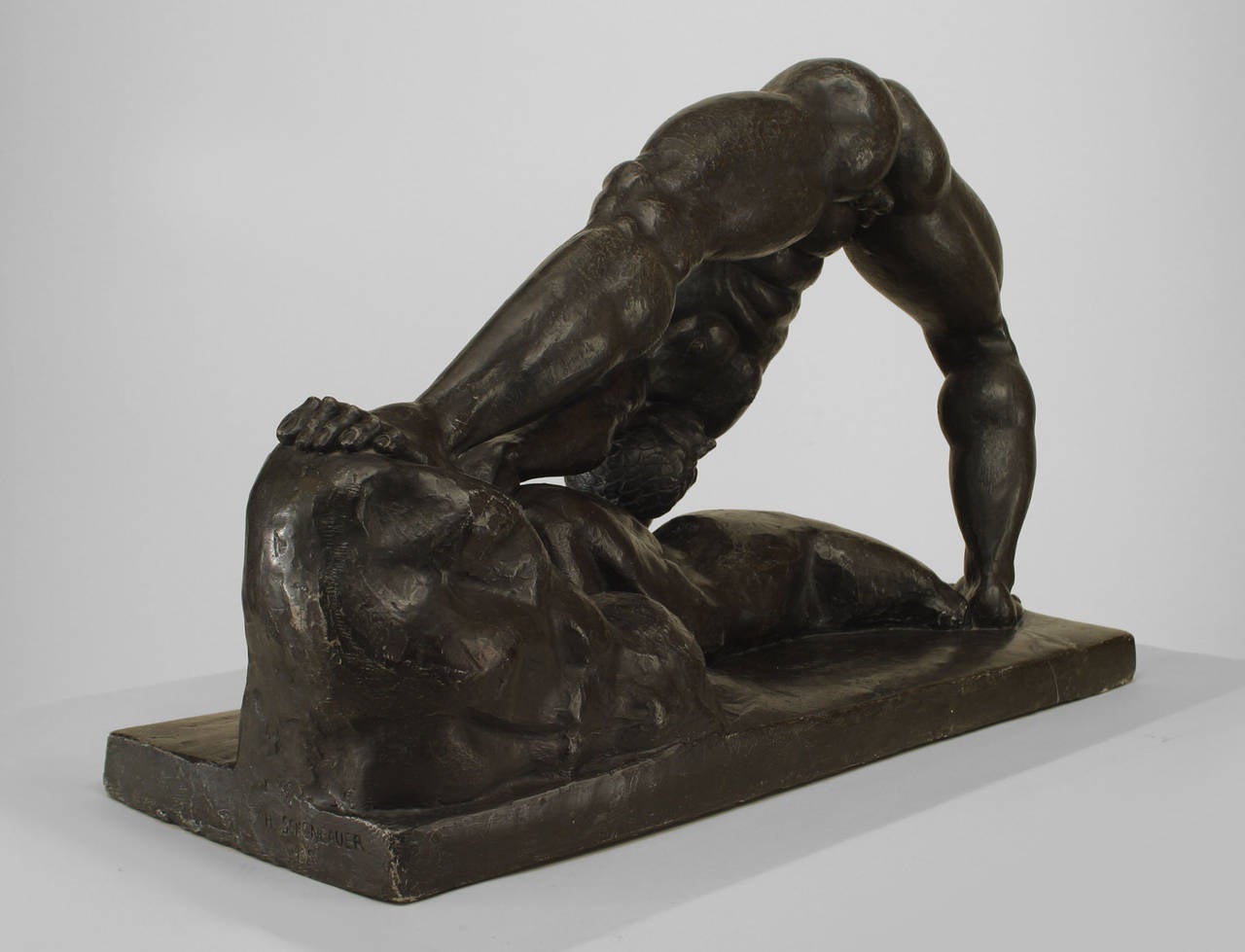 Modern cast resin copy of a Hungarian Art Deco sculpture signed by Henry Scheonbauer. The sculpture shows a male figure with legs spread and standing on a rocky base.