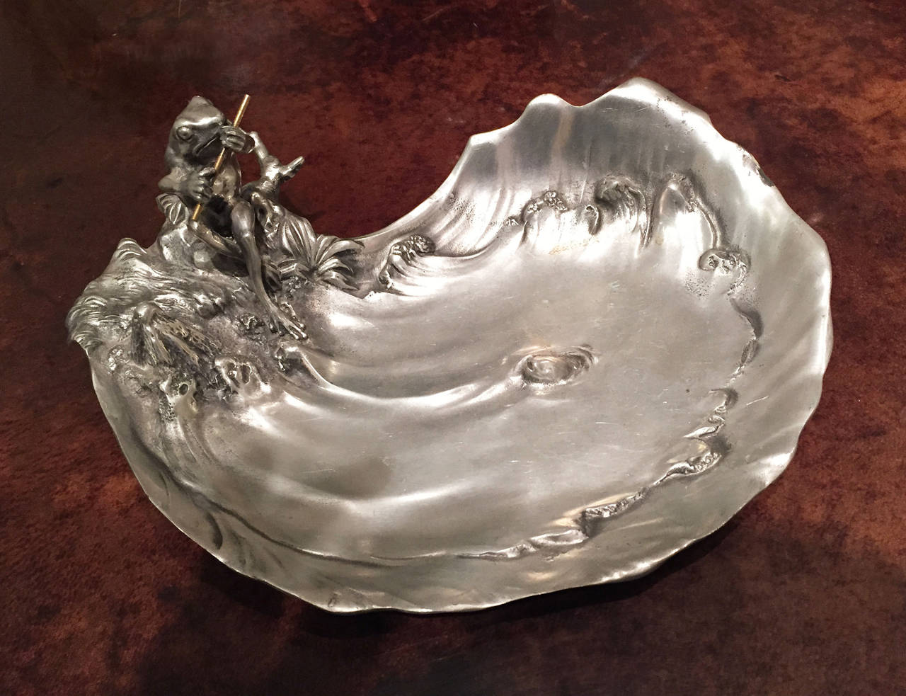 Italian Art Nouveau pewter ashtray in the form of a pond with a frog sitting
on the edge playing a flute. Stamped with hallmarks by Achille Gamba.