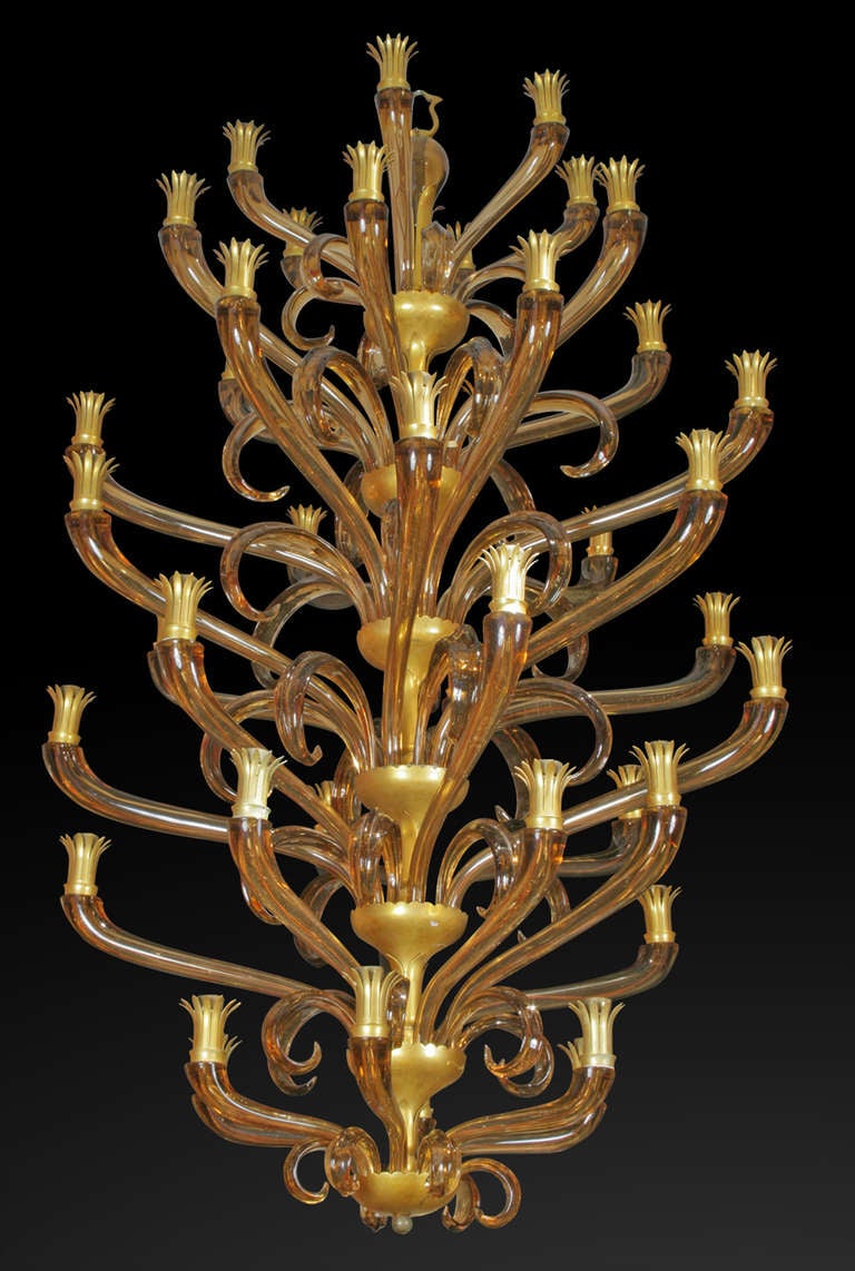 Italian Venetian Murano (1950s) amber glass chandelier with 42 arms spread over 7 tiers with glass scrolls. (ARCHIMEDE SEGUSO)
