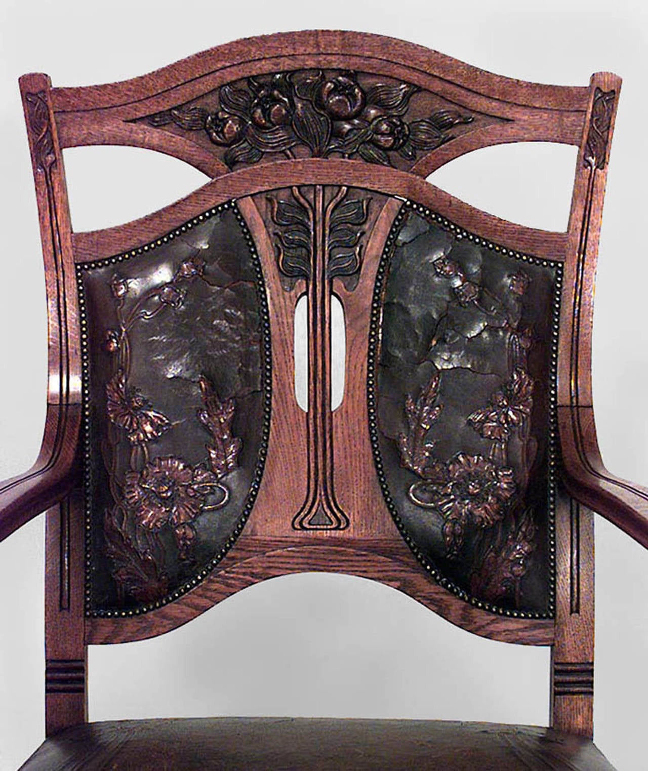 Set of 8 Belgian Art Nouveau carved oak chairs with floral embossed leather upholstered seat and back, with rips. 2 arm chairs: 24¬æ