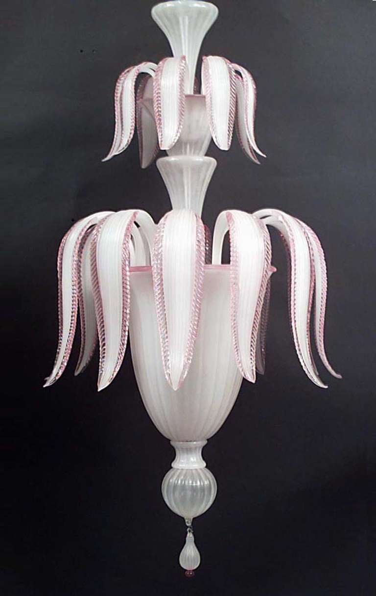 Lustre en verre opalin blanc de Murano du milieu du siècle dernier (années 1940) avec un design de plumes à deux niveaux et une bordure en verre rose appliquée avec un épi de faîtage en bas.
