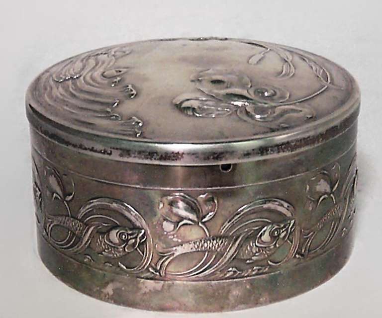 French Art Nouveau silver round shaped box with cranberry glass liner and floral design.
