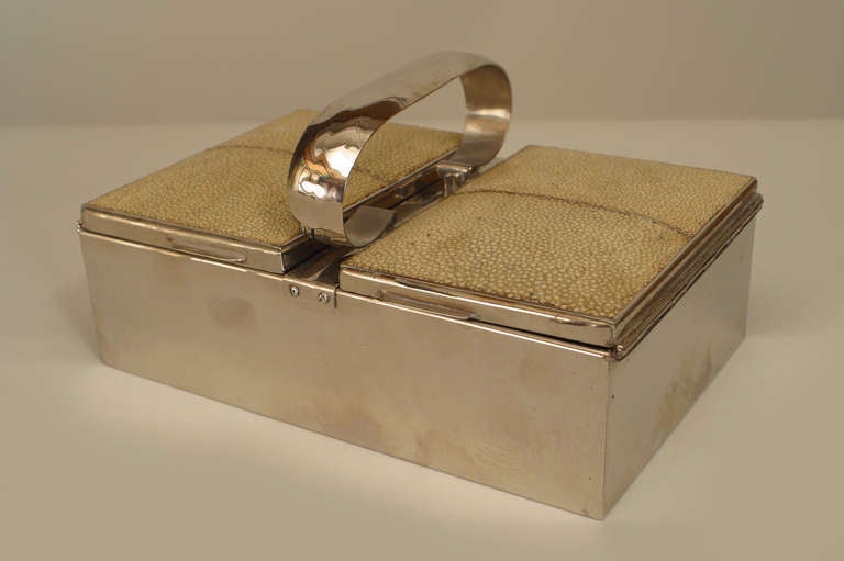 English Art Deco silver plate box whose lid features a center handle from which shagreen side panels hinge on either side.
