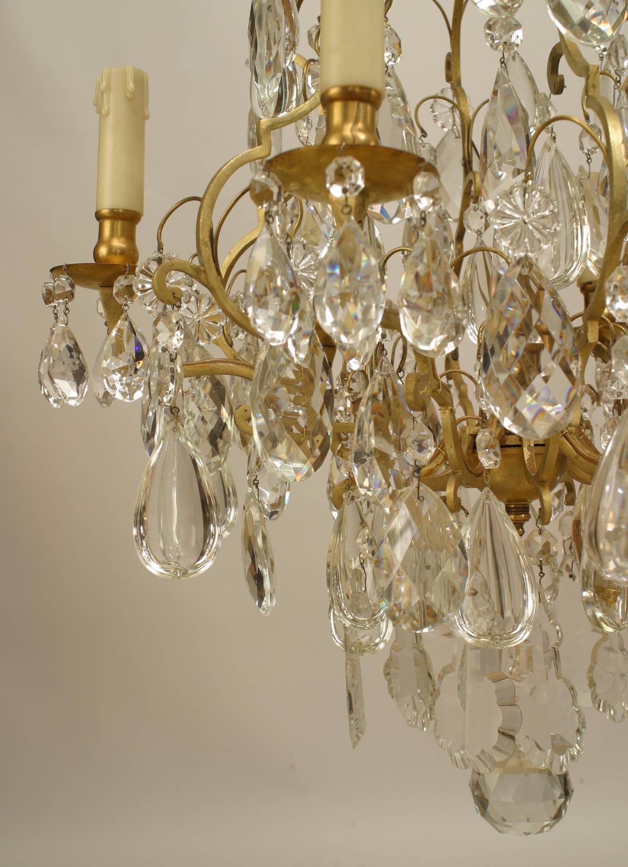 Turn of the century French Louis XV style bronze 6 light chandelier with multiple
tiers of shaped crystal drops.