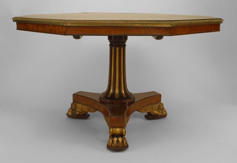 Table de centre de style Régence anglaise (vers 1810), montée en bronze doré, dorée à la feuille, en thuya et en acajou, à plateau octogonal basculant, avec plateau à bandes croisées en calamandre et pieds en pattes de lions ailés.
