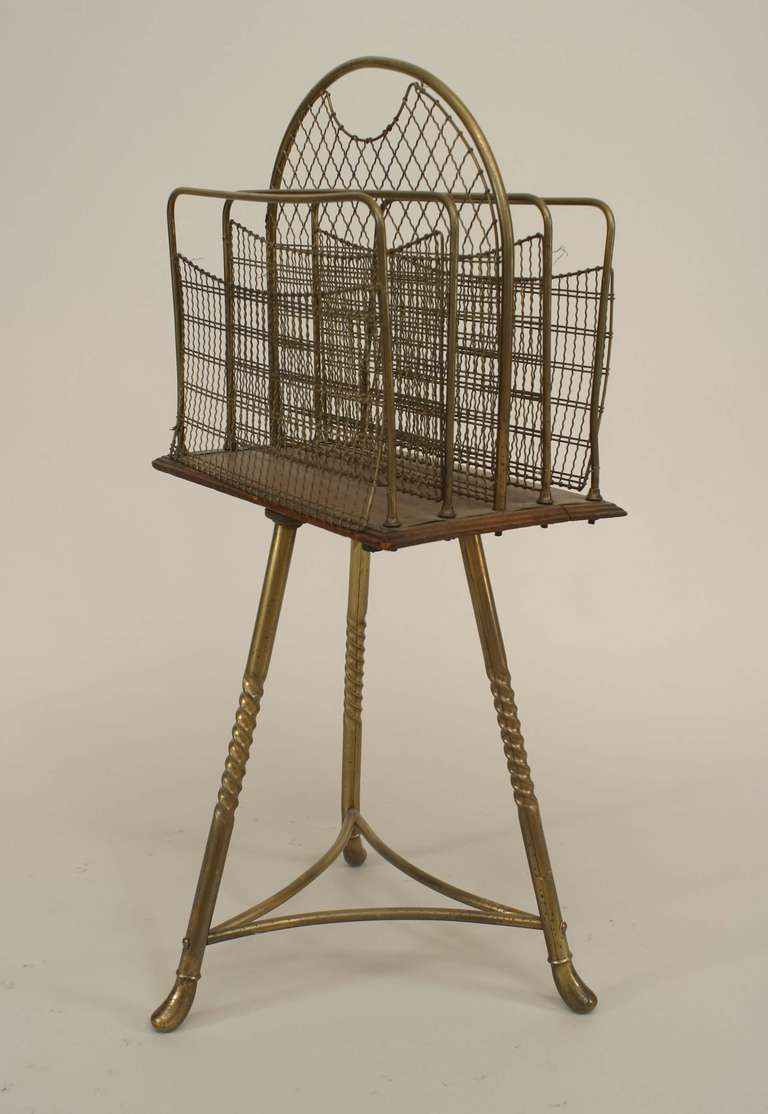 English Victorian brass and wood revolving book stand with 4 brass mesh divider sections on brass tripod base with twisted legs.
