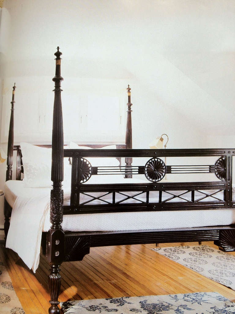 Nineteenth century Anglo-Indian king sized bed composed of rosewood in an open, geometric form. The bed features striking ornamental carving such as fluted and floral-design posts as well as head and foot boards prominently displaying traditional