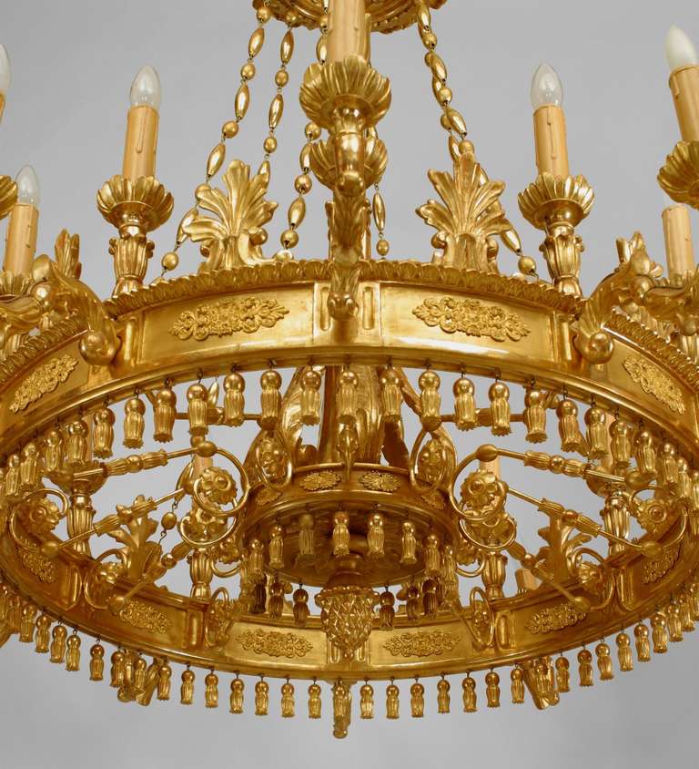  Austrian Biedermeier gilt wood chandelier featuring a feather tip corona suspending a central shaft and chains above two tiers of twenty-four acanthus-sheathed arms with a pine cone finial and tassel-form apron.
