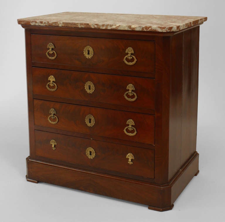 Cómoda de caoba de estilo Imperio francés (s. XIX) con 4 cajones y tiradores y escudos de bronce, con tapa de mármol marrón.
