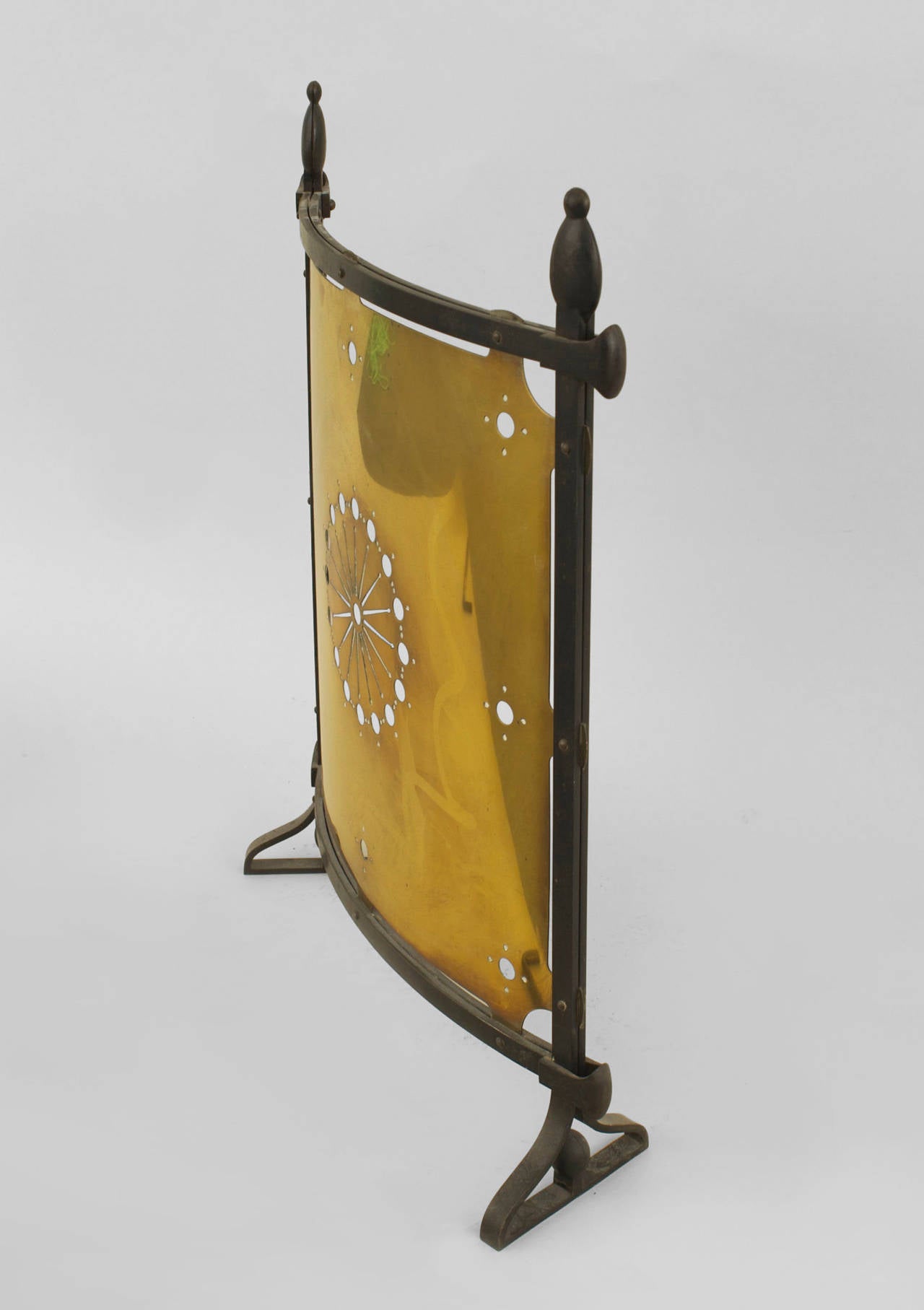 English Arts & Crafts (Aesthetic Movement) fire screen with an iron frame
having finials surrounding a bowed brass screen with a pierced round center.