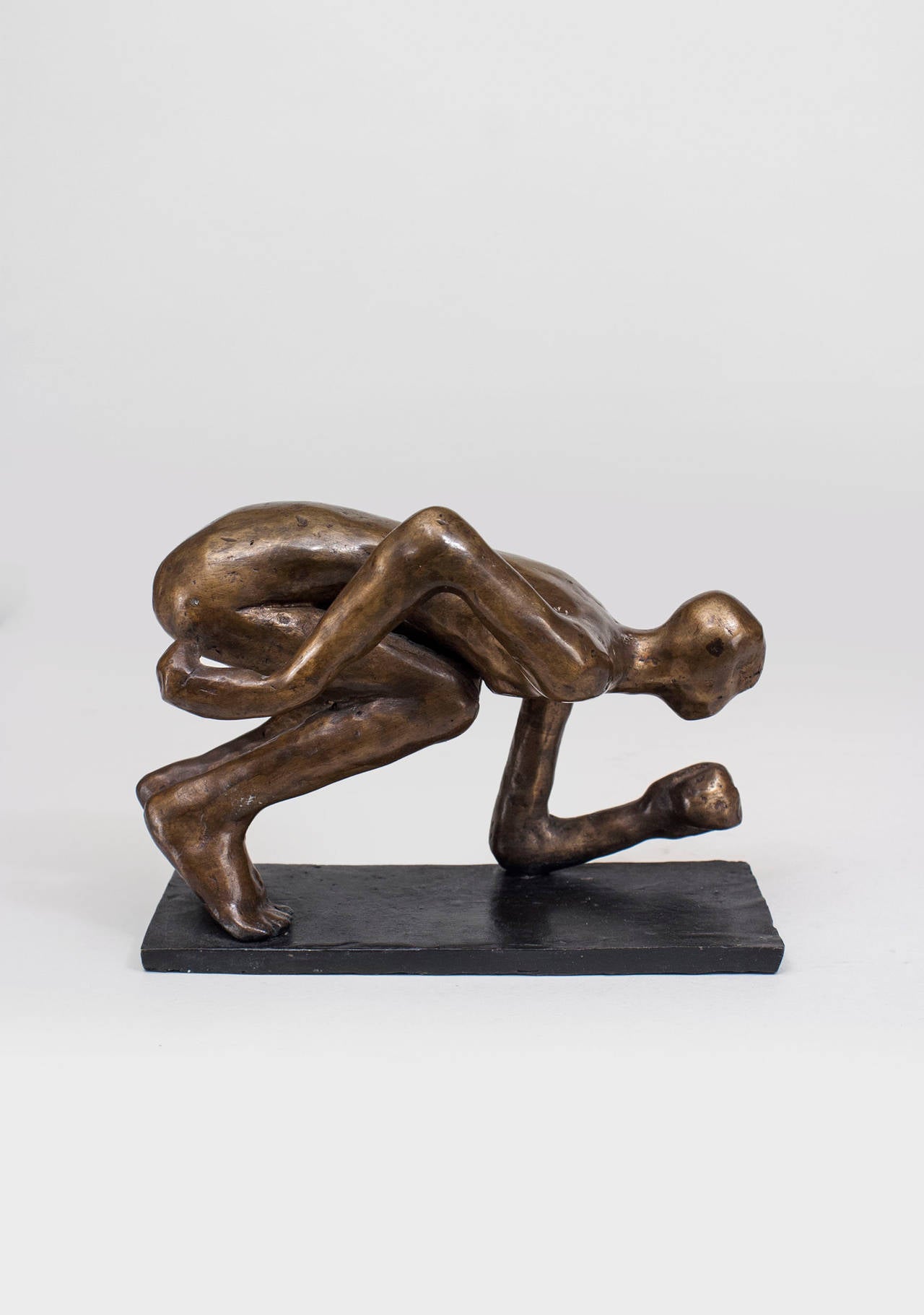 American Post-Modern Design bronze sculpture of a kneeling figure with lowered arms on a narrow rectangular base, (signed: CAROL BRUNS, 2003)

