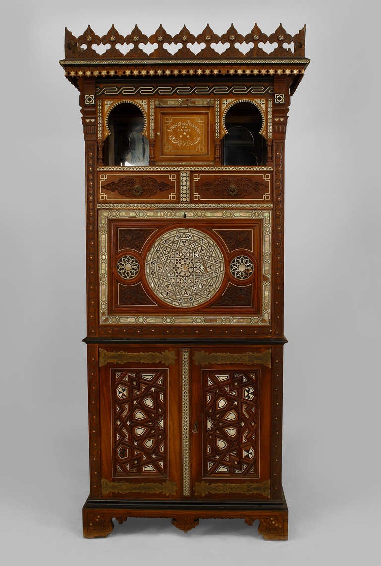 Moorish style Egyptian secretary composed of walnut inlaid and trimmed with ivory, bone, and ebony in extraordinarily complex geometric patterns inspired by Islamic architecture. Traditional Middle Eastern carvings and cut outs, such as mihrab-form