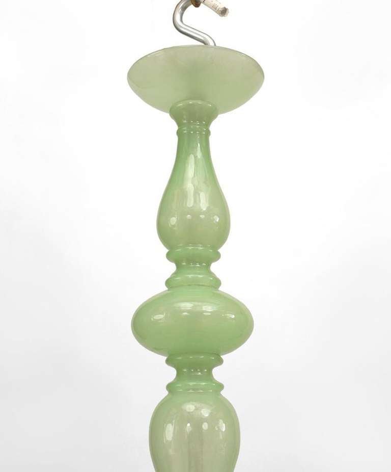Attributed to Venini, this 1950's Venetian chandelier is composed of celedon green Murano glass and features five scroll arms, a segmented, bulbous stem, and a round bottom finial.