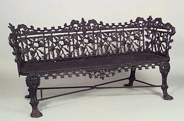 Nineteenth century English painted iron outdoor settee featuring a perforated seat, claw feet, and a morning glory pattern floral filigree back.