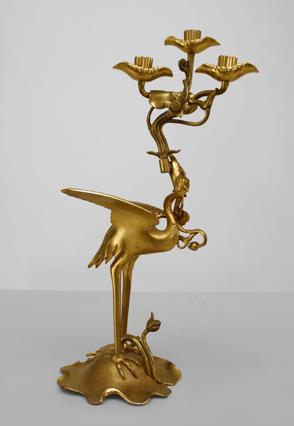 Coppia di figure di airone dorato in bronzo in stile Reggenza inglese (XIX secolo), in piedi su fiori di loto, che reggono candelabri a 3 bracci (PREZZO IN COPPIA)
