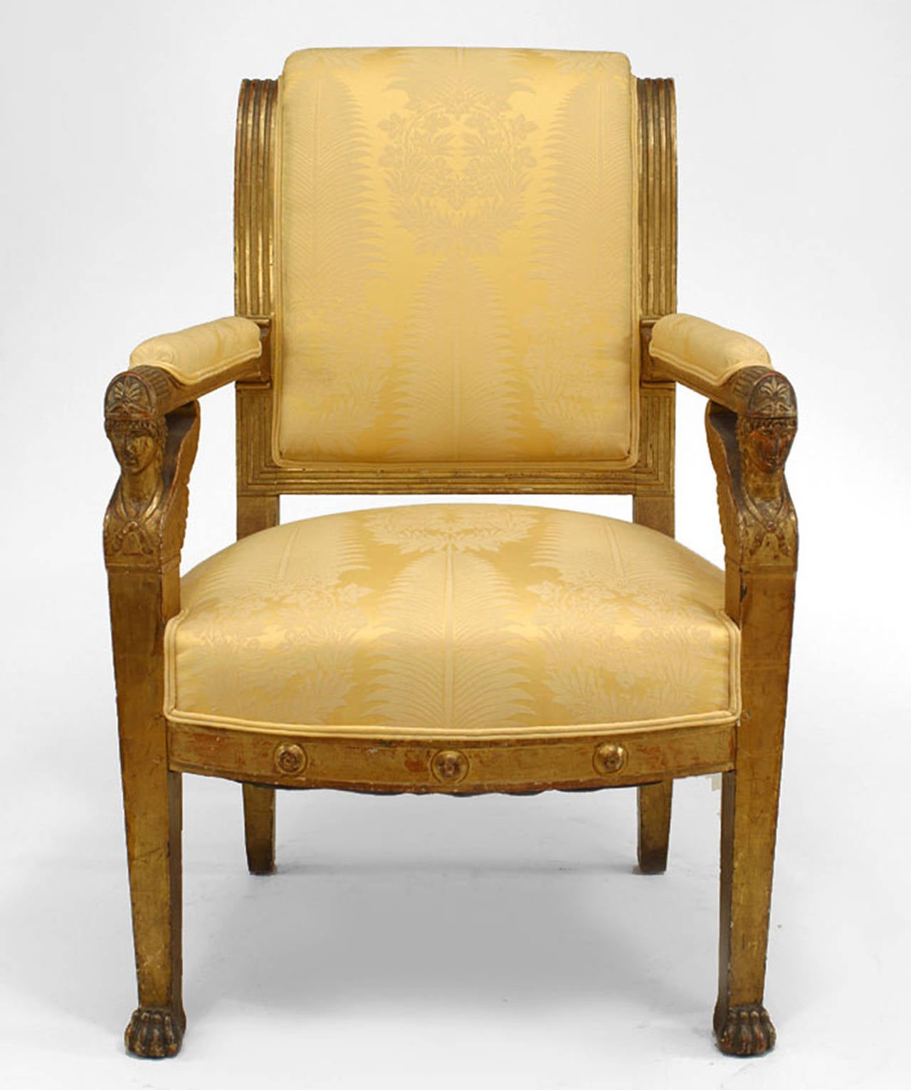 French Empire arm chair with sphinx heads and pale gold damask upholstery.
