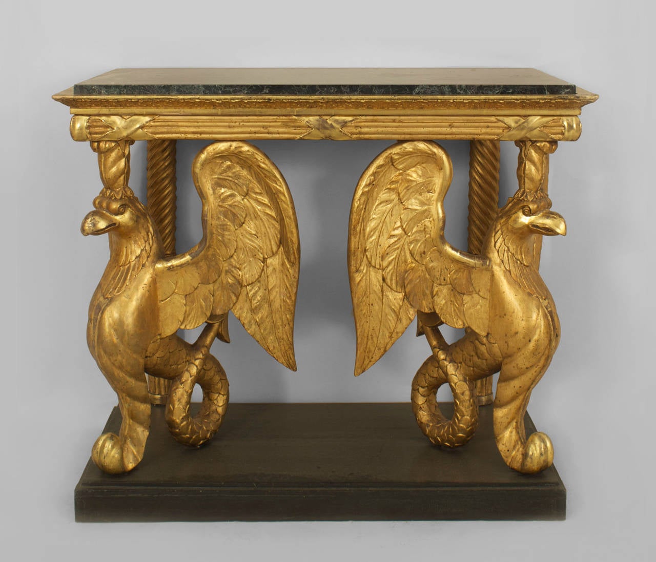 Early 19th century continental Swedish Empire gilt console having a pair of carved stylized
winged griffins with tails resting on an ebonized platform base with an inset marble top.