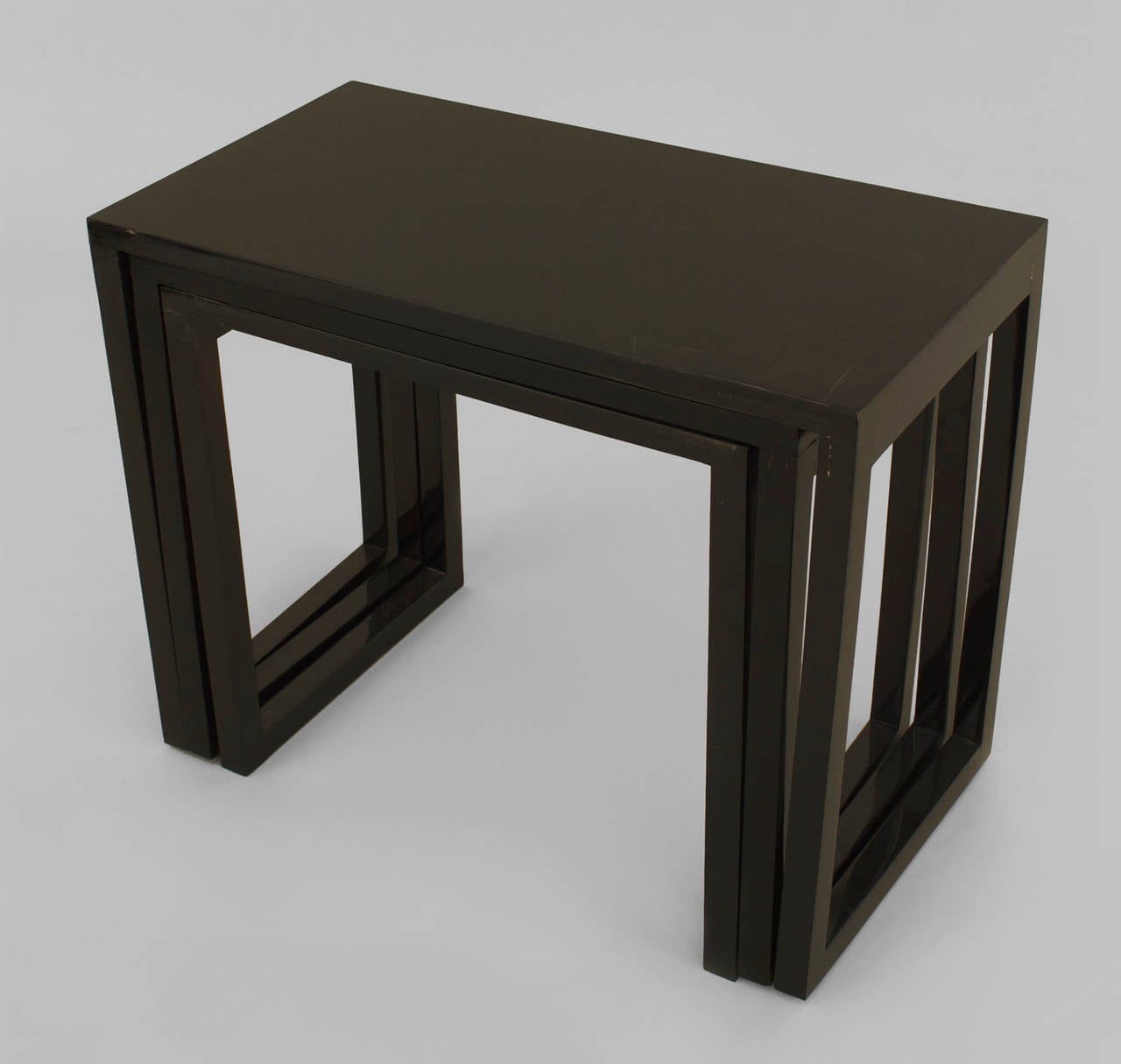 American modern black lacquered nest of three tables with a geometric form.