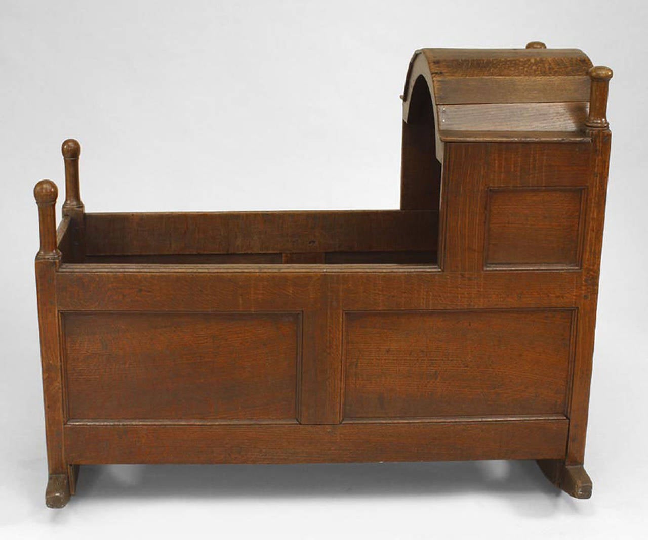 American Country (Wm. & Mary style-17/18th Cent) oak paneled cradle with hooded front section with finials.
