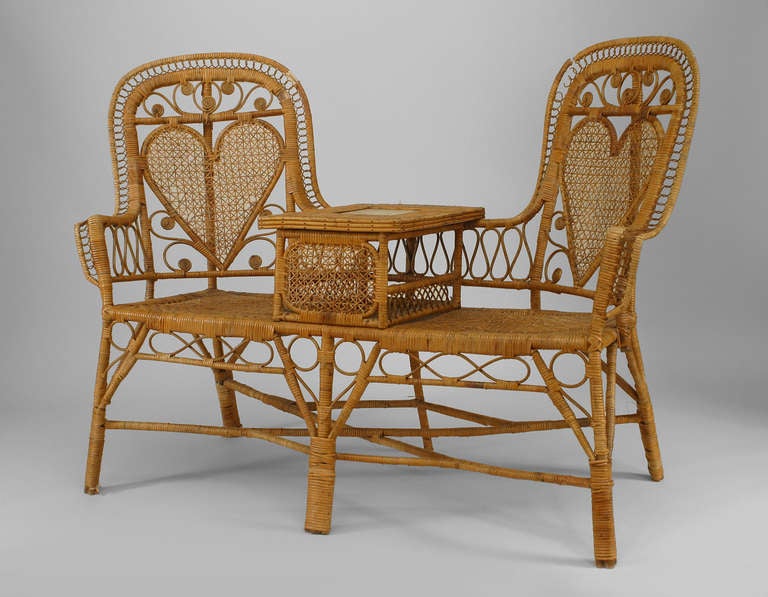 Nineteenth century French wicker tete-a-tete or conversation seat featuring two chairs with woven heart-shaped back panels and cushioned seats flanking a white marble table top.
