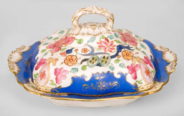 Lidded porcelain plate dating to 19th century France with red, white, and blue floral decorations and gilt trim.