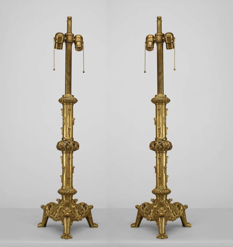 Pair of English Renaissance style (19/20th Century) brass column altar stick form table lamp with 3 rings and resting on triangular filigree base with claw feet (PRICED AS Pair).
