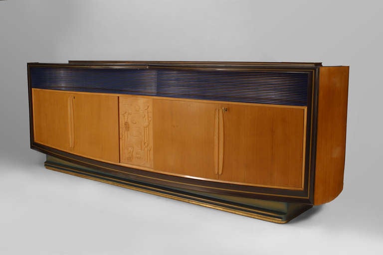 Italian mid-century (1950s) walnut & maple sideboard with 2 Pair of doors centering a carved relief panel above a blue & gold painted shelf with a blue glass on top. (Attributed to VITTORIO DASSI/ ENZO FERRARI).
         