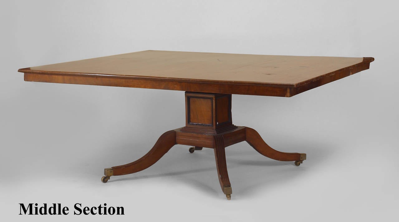 English Regency (19th Century) mahogany dining table with three square pedestal bases having four fluted splayed legs with ebonized trim
