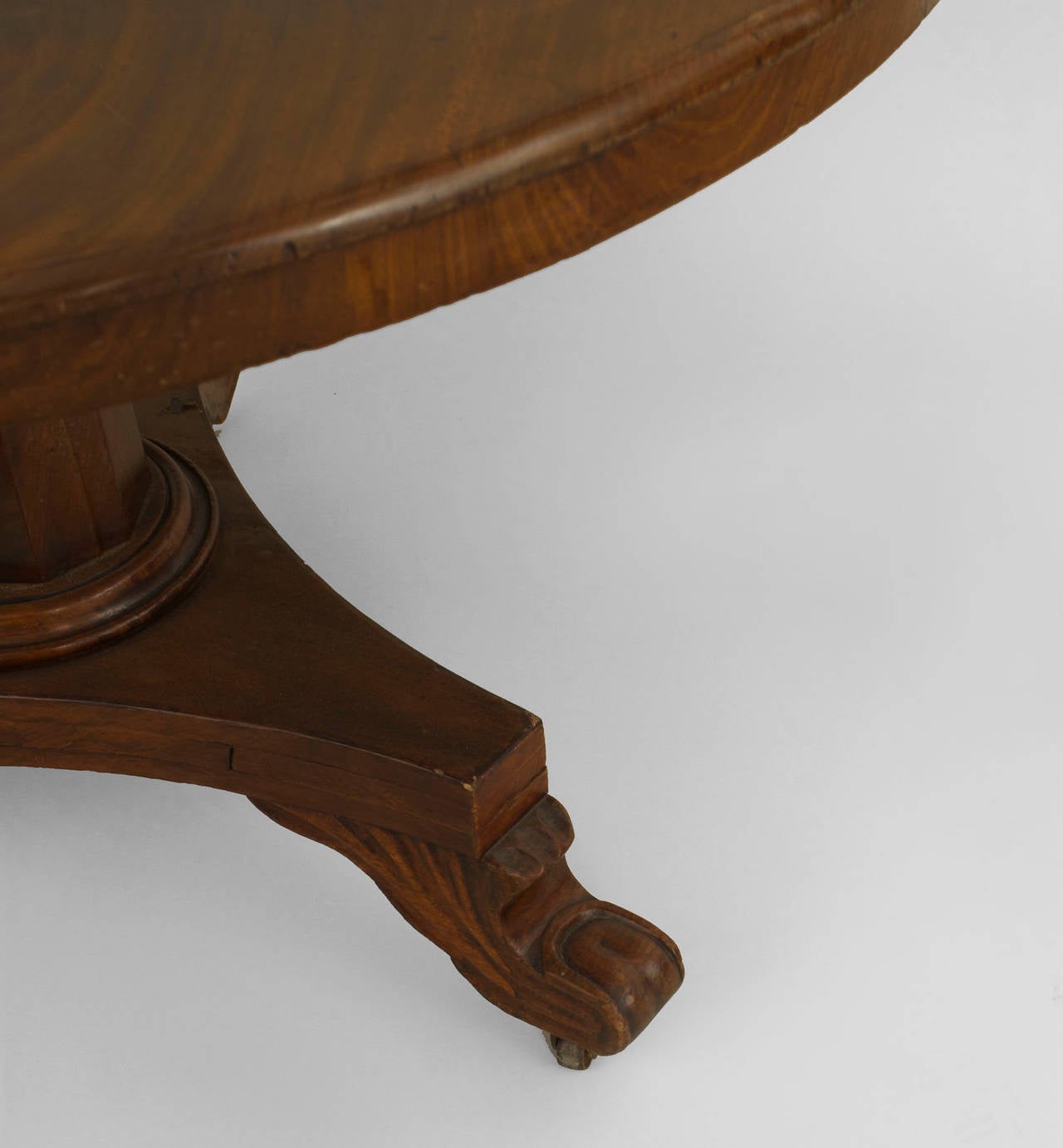 English Regency mahogany center table the book-matched top with short apron
supported by a central column all on a tripartite base with claw feet.