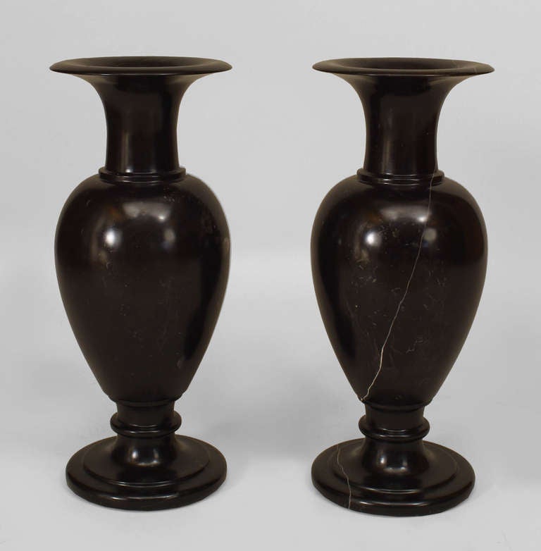 Pair of Neoclassic black fossilized marble urns with circular plinths, likely of nineteenth century Swedish origin.