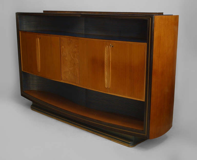 Italian Mid-Century (1950s) walnut & maple sideboard with and open bottom shelf below 2 Pair of doors centering a carved relief panel above a blue & gold painted shelf with a blue glass top. (Attributed to: VITTORIO DASSI/Enzo Ferrari)
