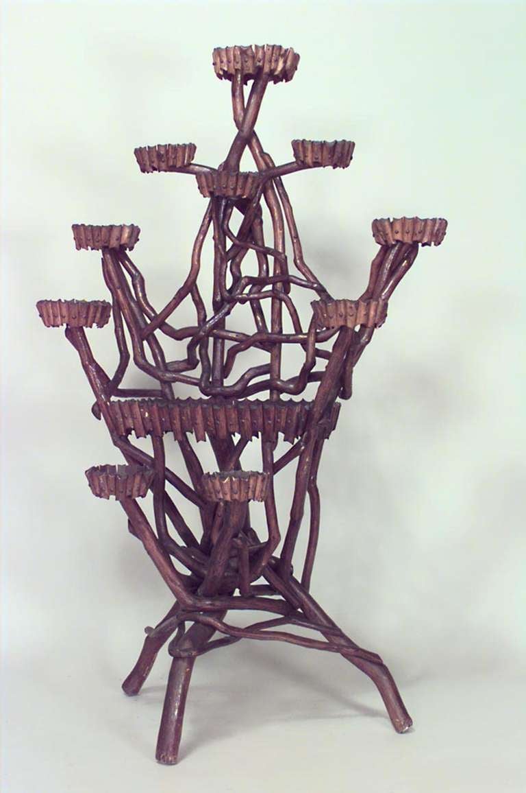 Nineteenth century Rustic Continental natural twig form plant stand supported by three legs and featuring ten planters staggered at different levels around a large, centered shelf.