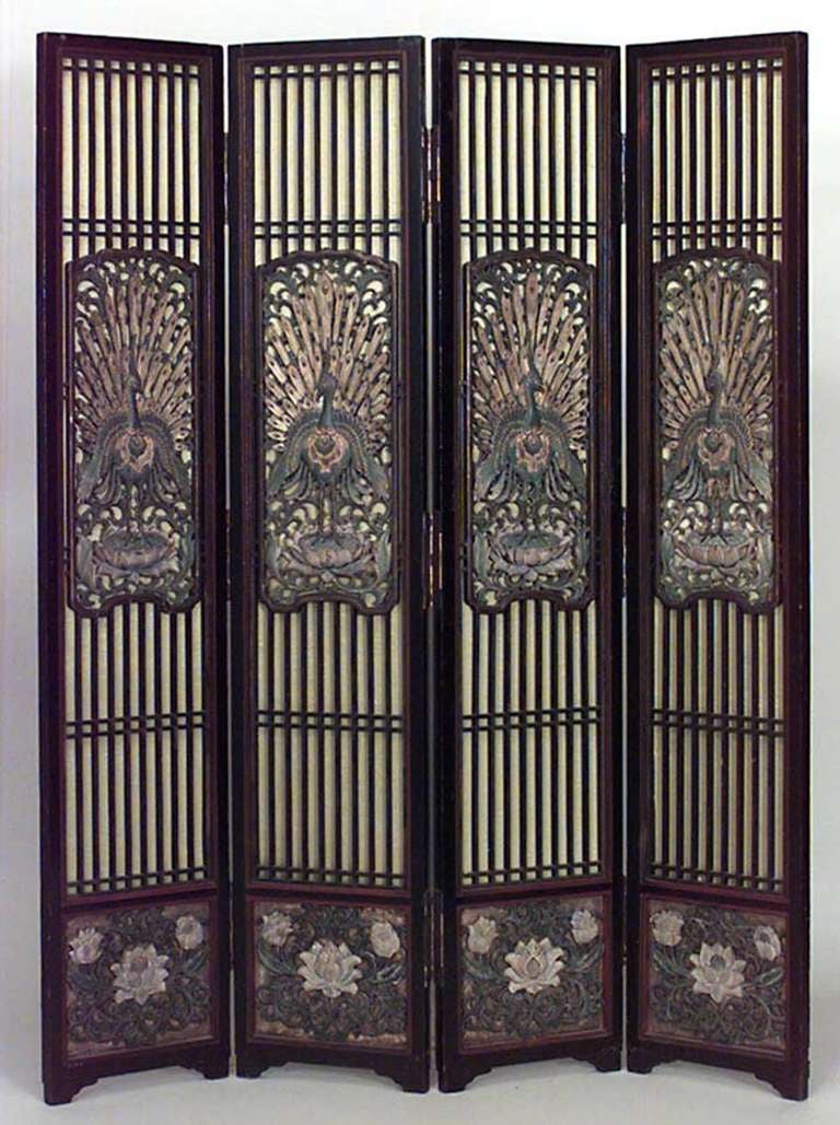 Polychromed Asian screen featuring a carved peacock design on each of its four panels.