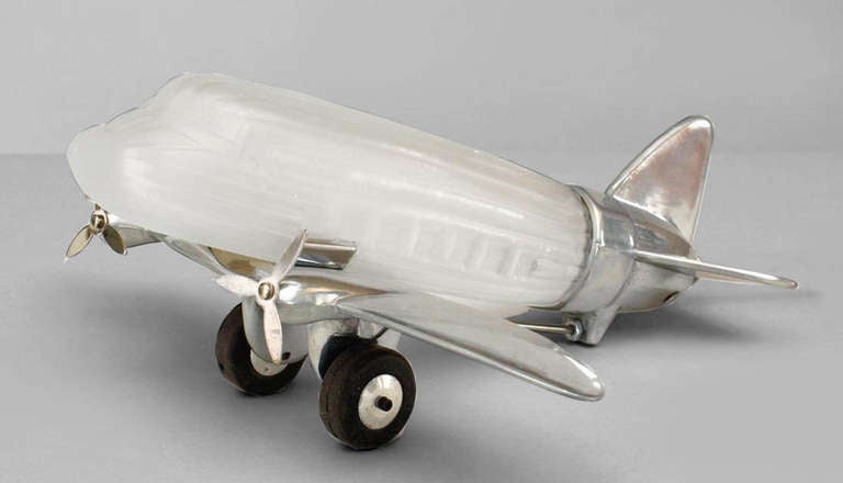French Art Deco style table lamp in the form of an airplane with a frosted glass cabin and chrome wings, propellors, and tail.
