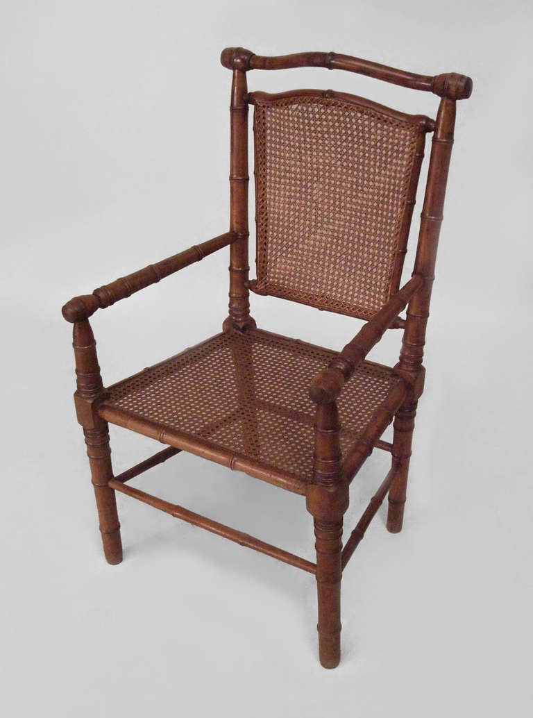 Maple faux bamboo armchair of possible nineteenth century French  origin. The chair features a cane seat and back with a shaped top rail and box form stretcher base.
