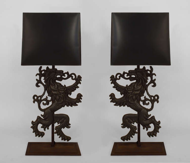 Pair of large nineteenth century English Renaissance style lions rampant composed of wrought iron and mounted as table lamps upon rectangular wooden bases beneath black lampshades. The pieces' backs are unfinished.