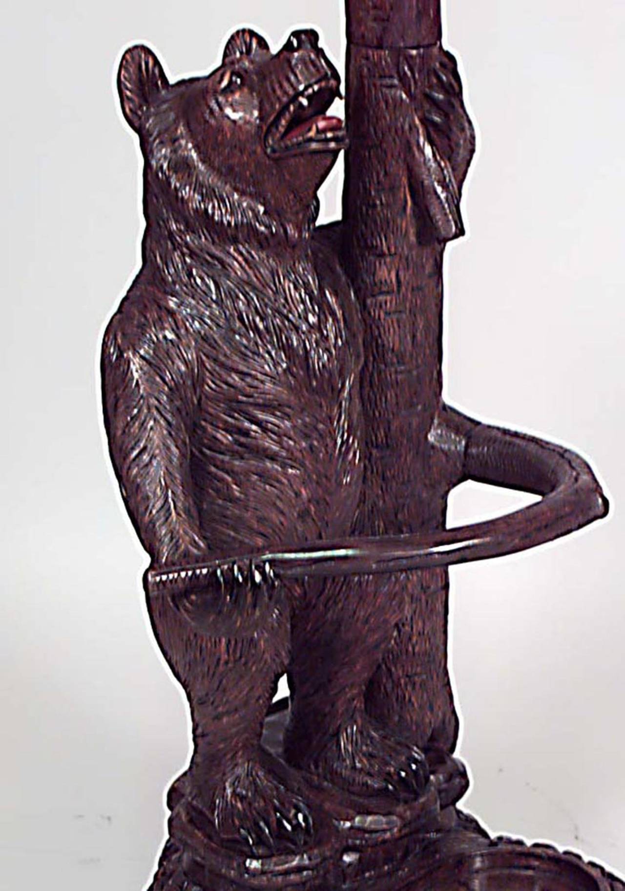 Rustic Black Forest style (20th century) walnut hatrack/umbrella stand with carved
bear base and two bears in hat tree upper section.