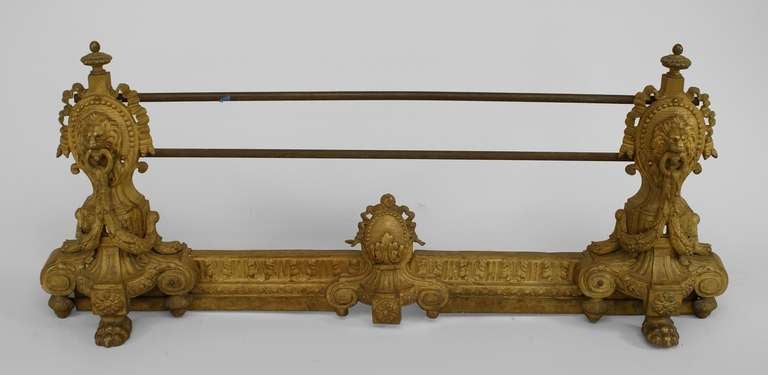 Nineteenth century Georgian gilt bronze fire fender with lions head and swag sides united by parallel bars.