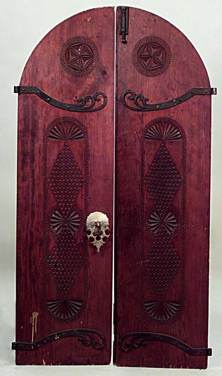 Pair of nineteenth century Moorish pine arched doors with wrought iron scroll design hinges, an etched brass handle, and Islamic inspired carvings.