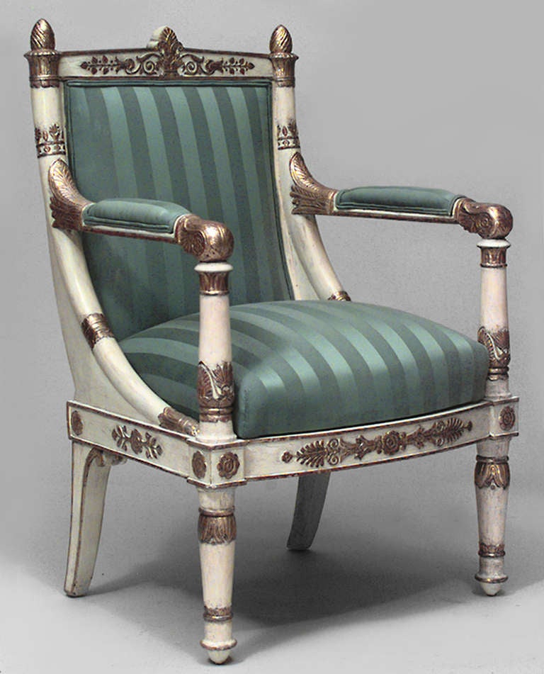 Paar offene, elfenbeinfarbene französische Empire-Sessel mit vergoldeten Verzierungen und grün gestreiften Sitz- und Rückenpolstern
