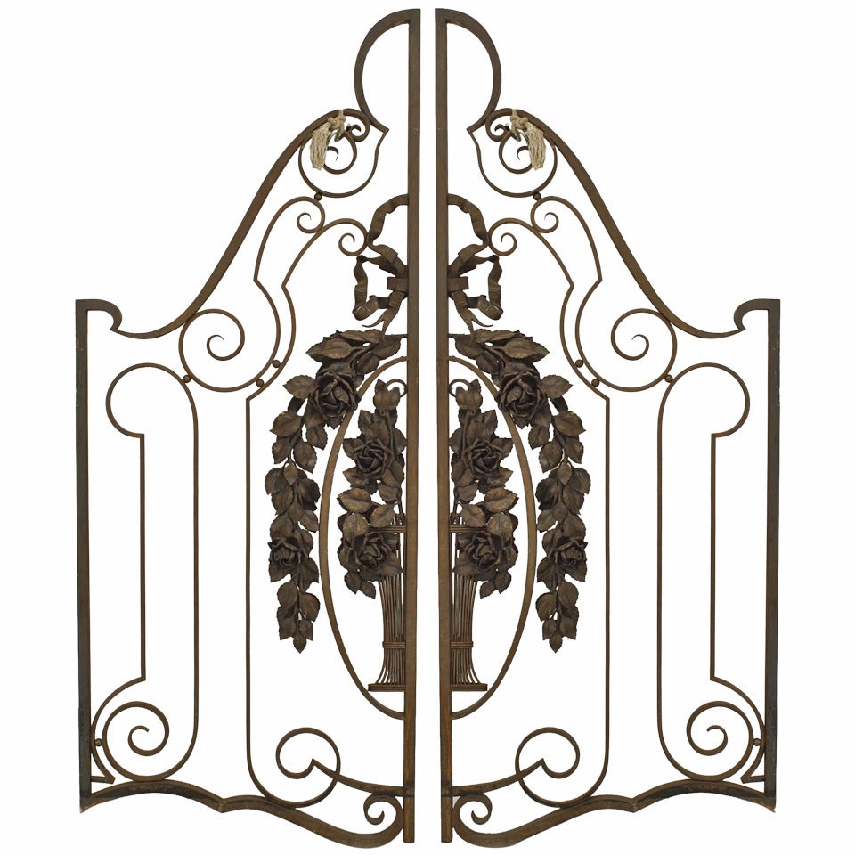 Pair of French Art Deco wrought iron and gilt trimmed gates with ribbon and floral wreath designs.