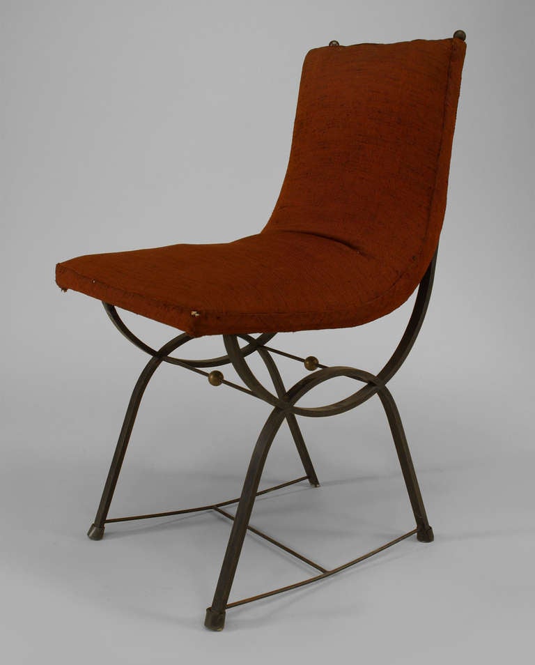 Attributed to French designer Gilbert Poillerat, this set of eight 1950s dining chairs are composed of iron with a 